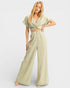Woman wearing a light green jumpsuit on a white background