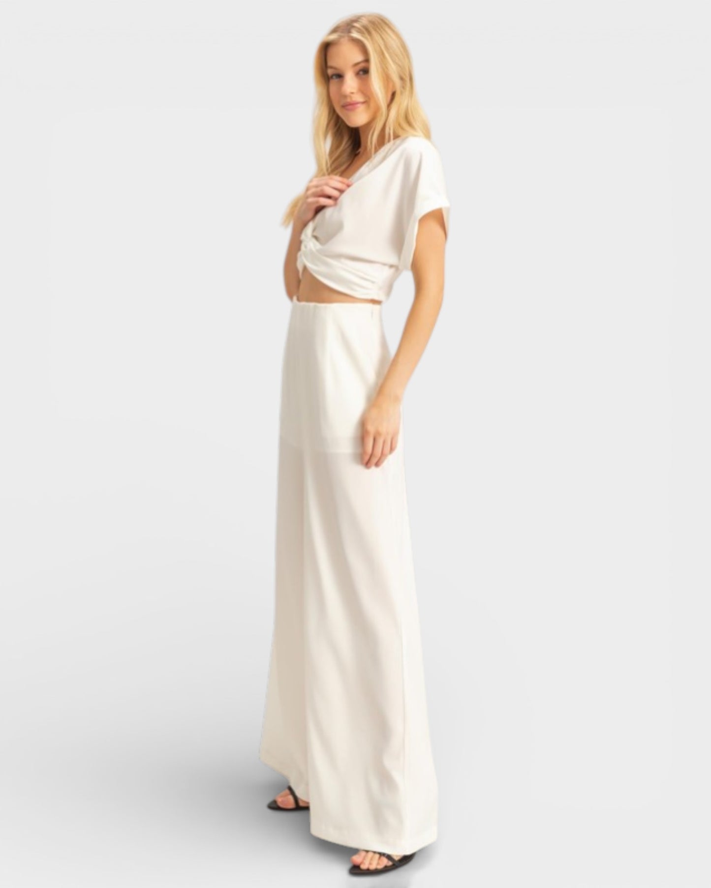 Woman wearing a white dress on a plain background