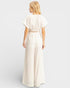 Woman wearing a white dress against a plain background