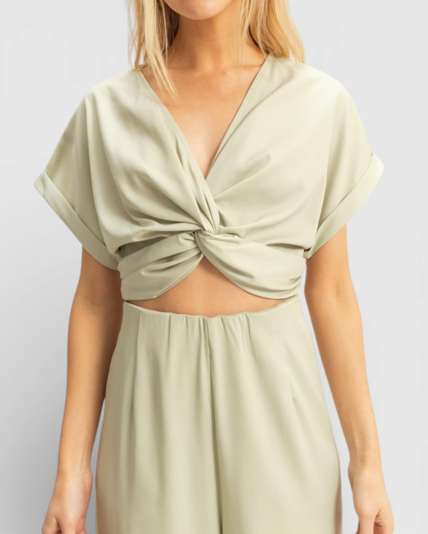 Light green dress with a knot detail on a plain background