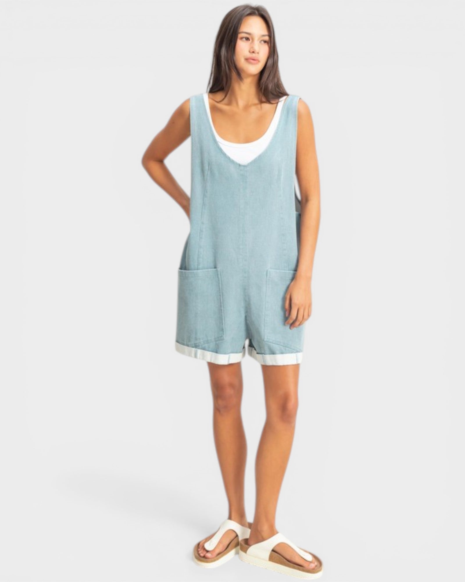 Woman wearing a light blue sleeveless dress on a white background
