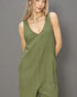 Woman wearing a green jumpsuit against a gray background
