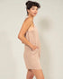 Woman wearing a beige dress against a plain background
