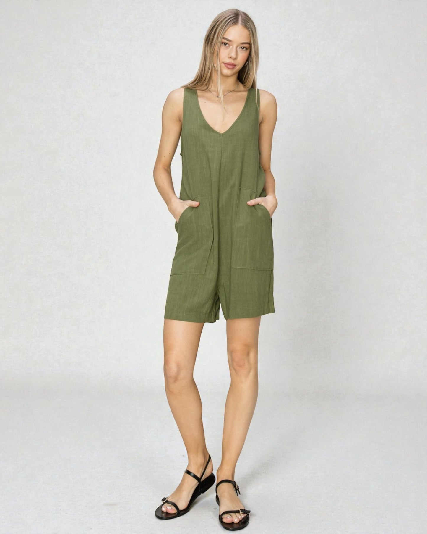 Woman wearing a green sleeveless dress on a white background