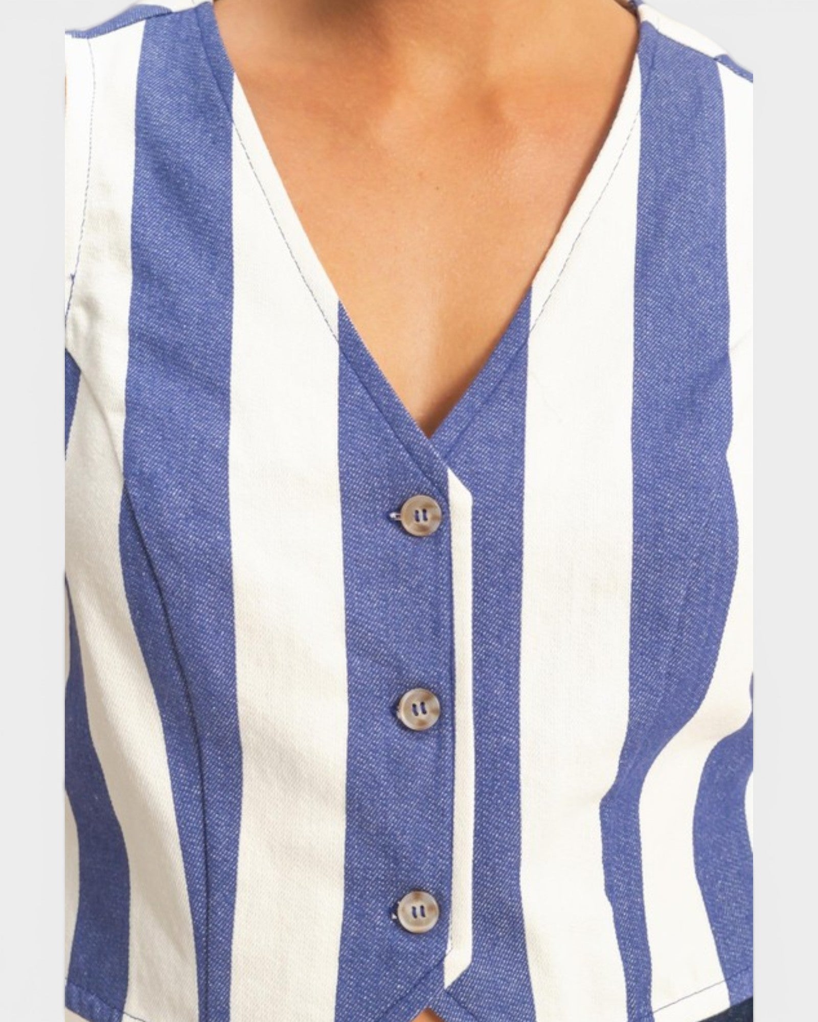Blue and white striped sleeveless top with buttons on a plain background