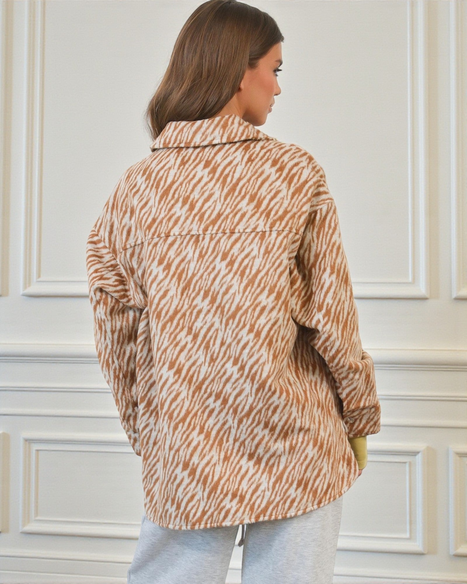 Person wearing a patterned jacket in a neutral setting
