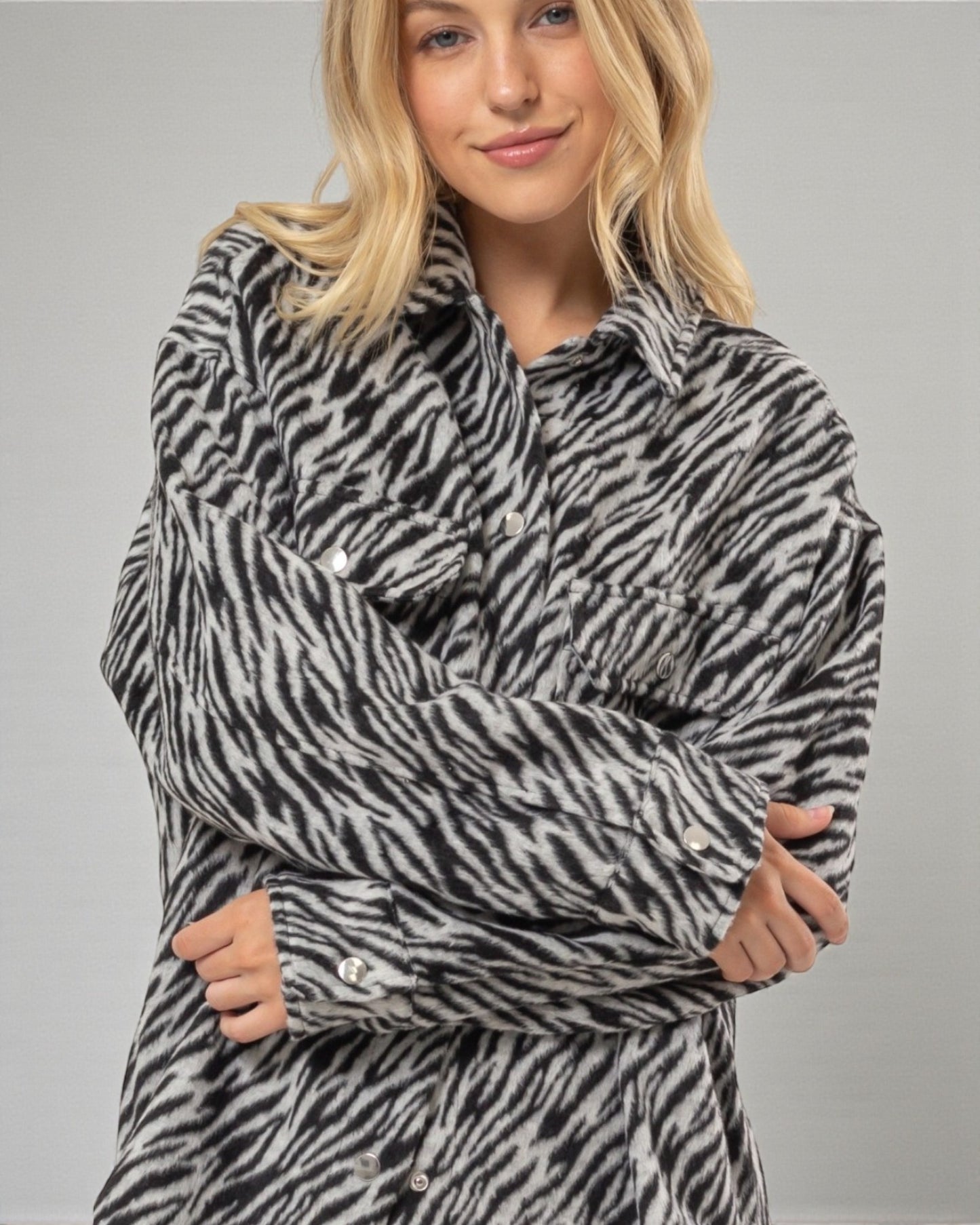 Person wearing a zebra print outfit against a gray background