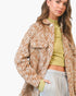 A woman wearing a brown and beige zebra-print overshirt over a yellow-green crop top and light gray sweatpants, photographed against a clean white studio background.
