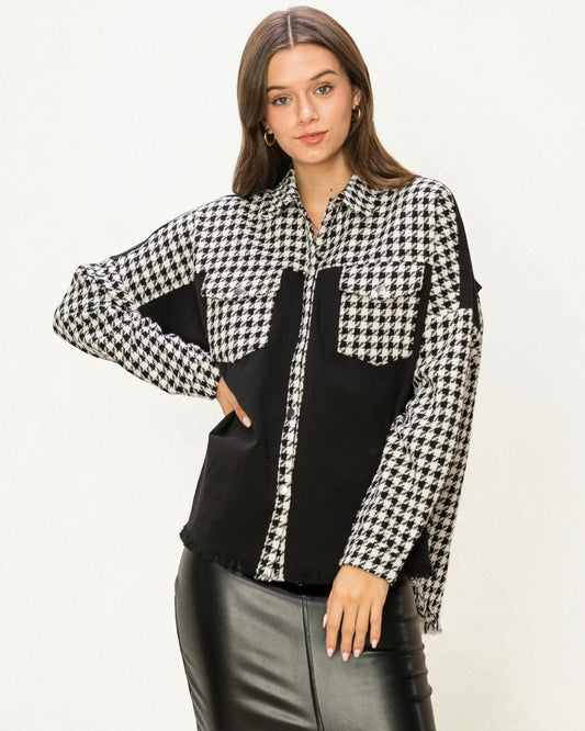 Woman wearing a black and white checkered shirt with a black panel on a white background