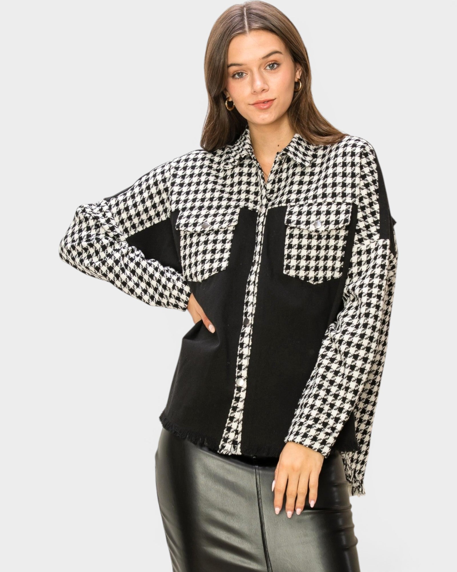 Woman wearing a black and white checkered blouse with a plain background
