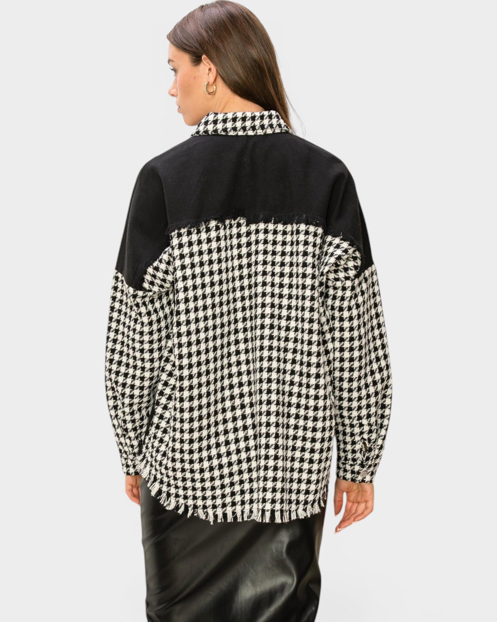 Person wearing a black and white checkered shirt on a light gray background