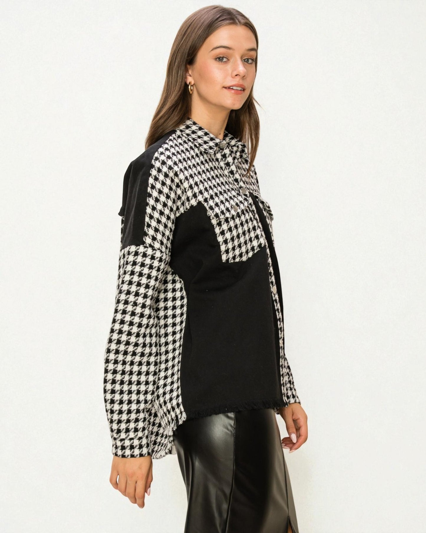 Woman wearing a black and white checkered jacket over a black top on a white background
