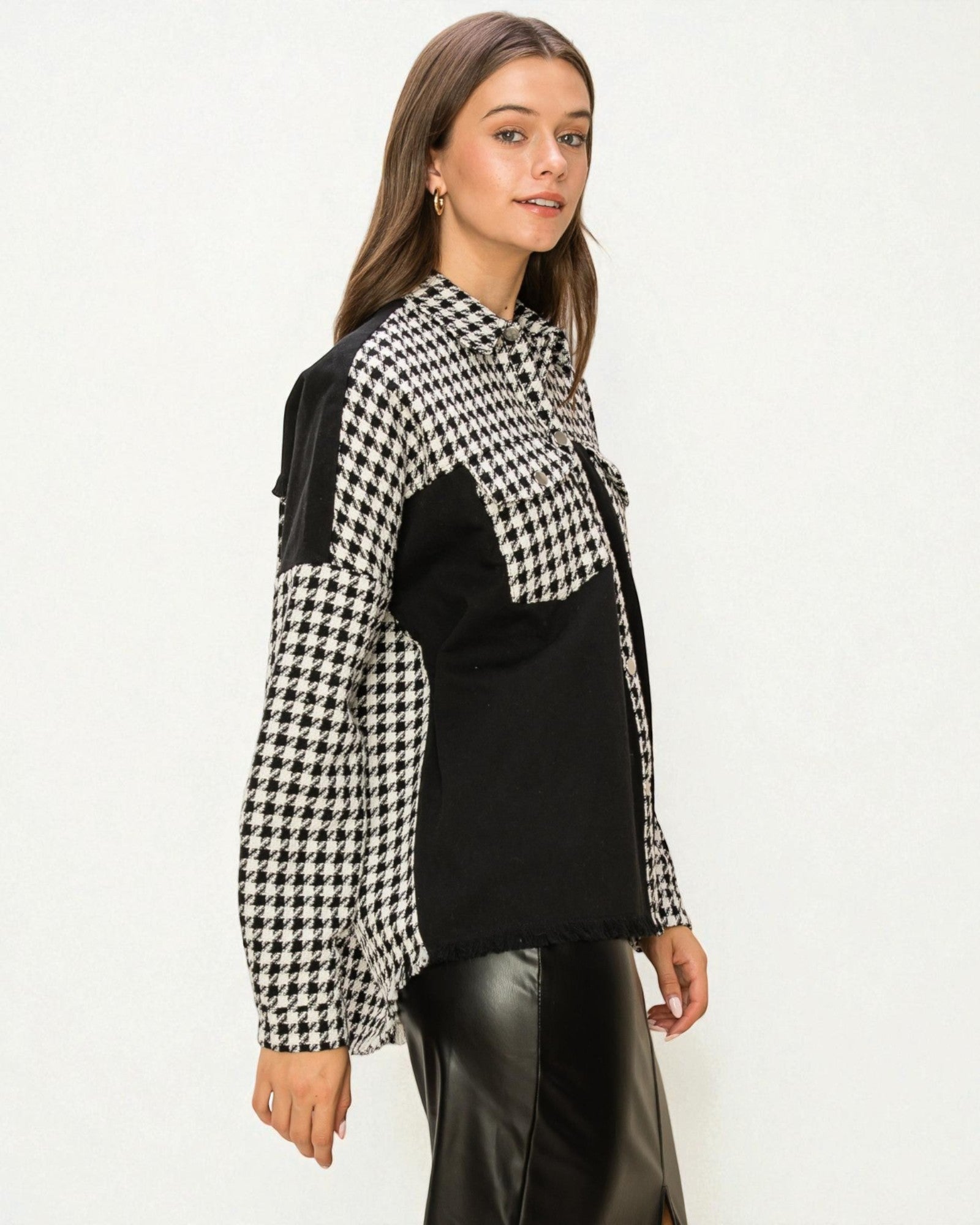 Woman wearing a black and white checkered jacket over a black top on a white background