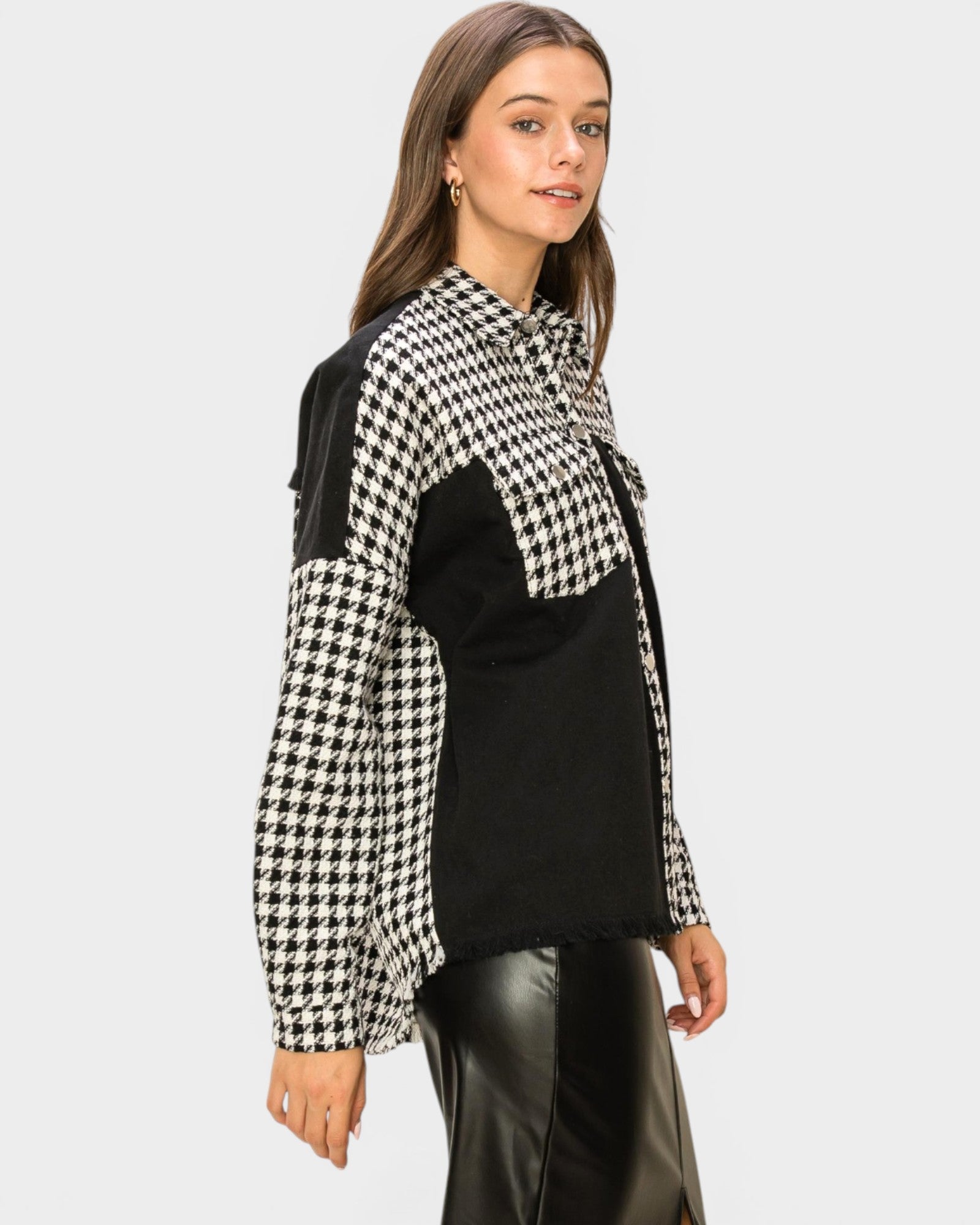 Woman wearing a black and white checkered scarf with a plain background