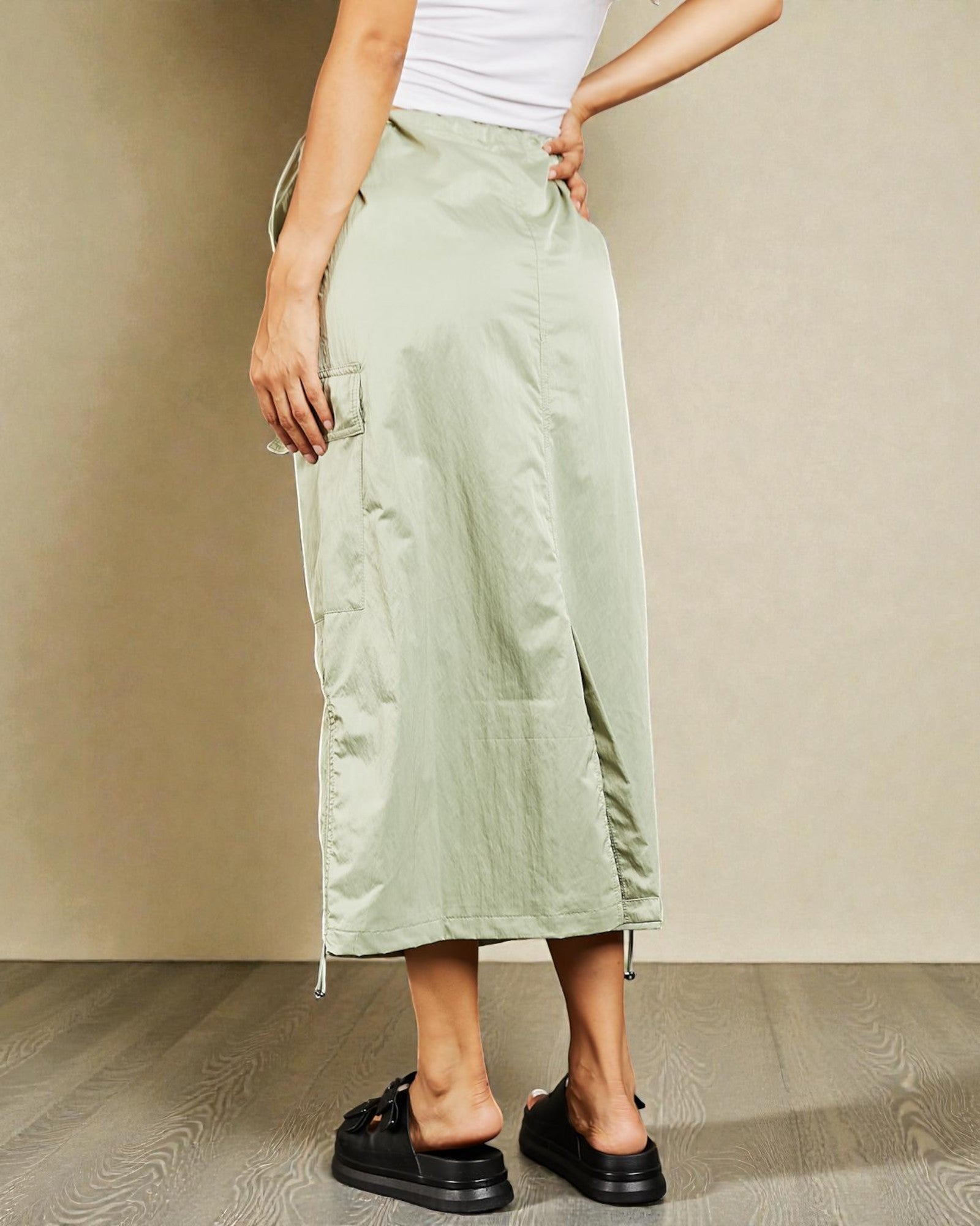 Person wearing light green cargo pants with a plain background