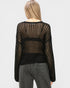 Person wearing a black sheer sweater over a black top with gray pants on a white background