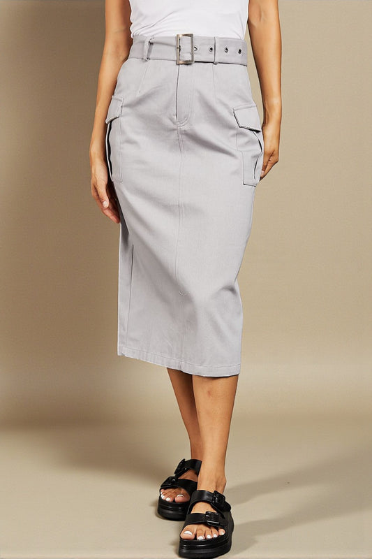 Person wearing a light gray skirt with a belt on a beige background