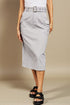 Person wearing a light gray skirt with a belt on a beige background