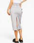 A model is shown from the waist down wearing a light gray high-waisted midi skirt with side pockets and a back slit, paired with black loafers against a plain white background.