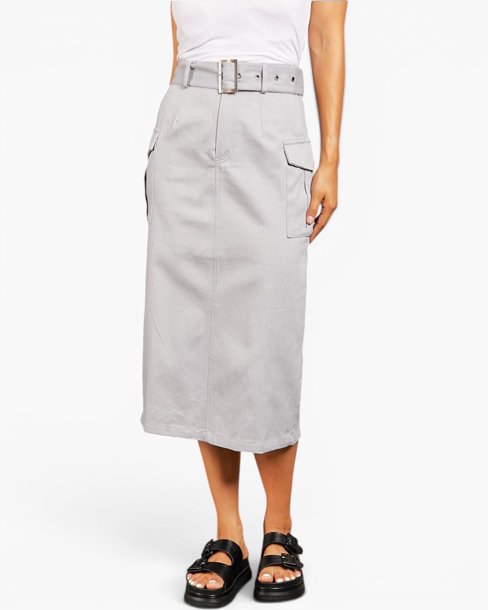 A model wearing a light gray mid-length utility skirt with a matching belt, styled with a white top and black slide sandals against a plain white background.