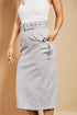 Person wearing a gray skirt with a belt against a beige background