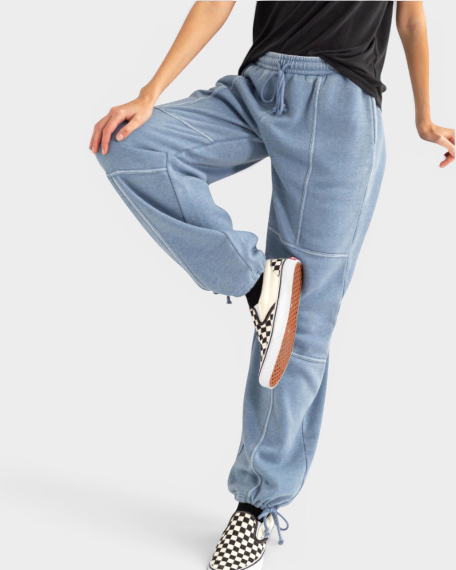 Light blue jogger pants worn by a person on a white background