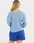 Woman wearing a blue knitted sweater and blue shorts on a white background