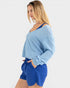 Woman wearing a light blue sweater and blue shorts on a white background