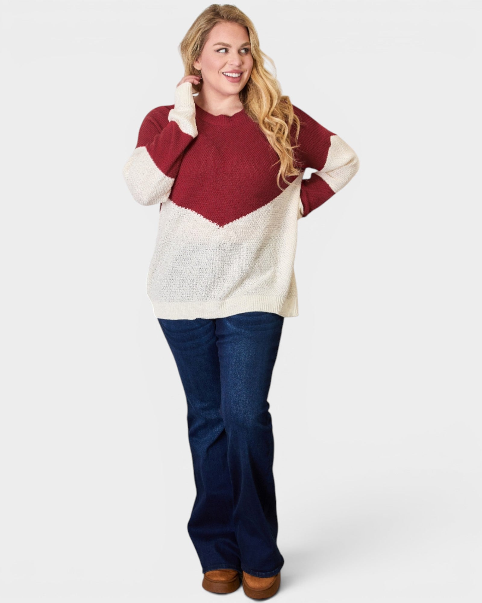 Woman wearing a red and white sweater with blue pants on a white background