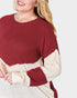 Person wearing a red and cream sweater on a white background
