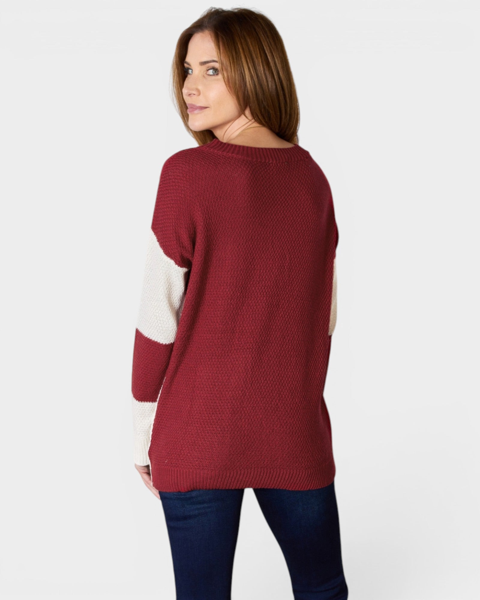 Woman wearing a red sweater with white sleeves on a white background