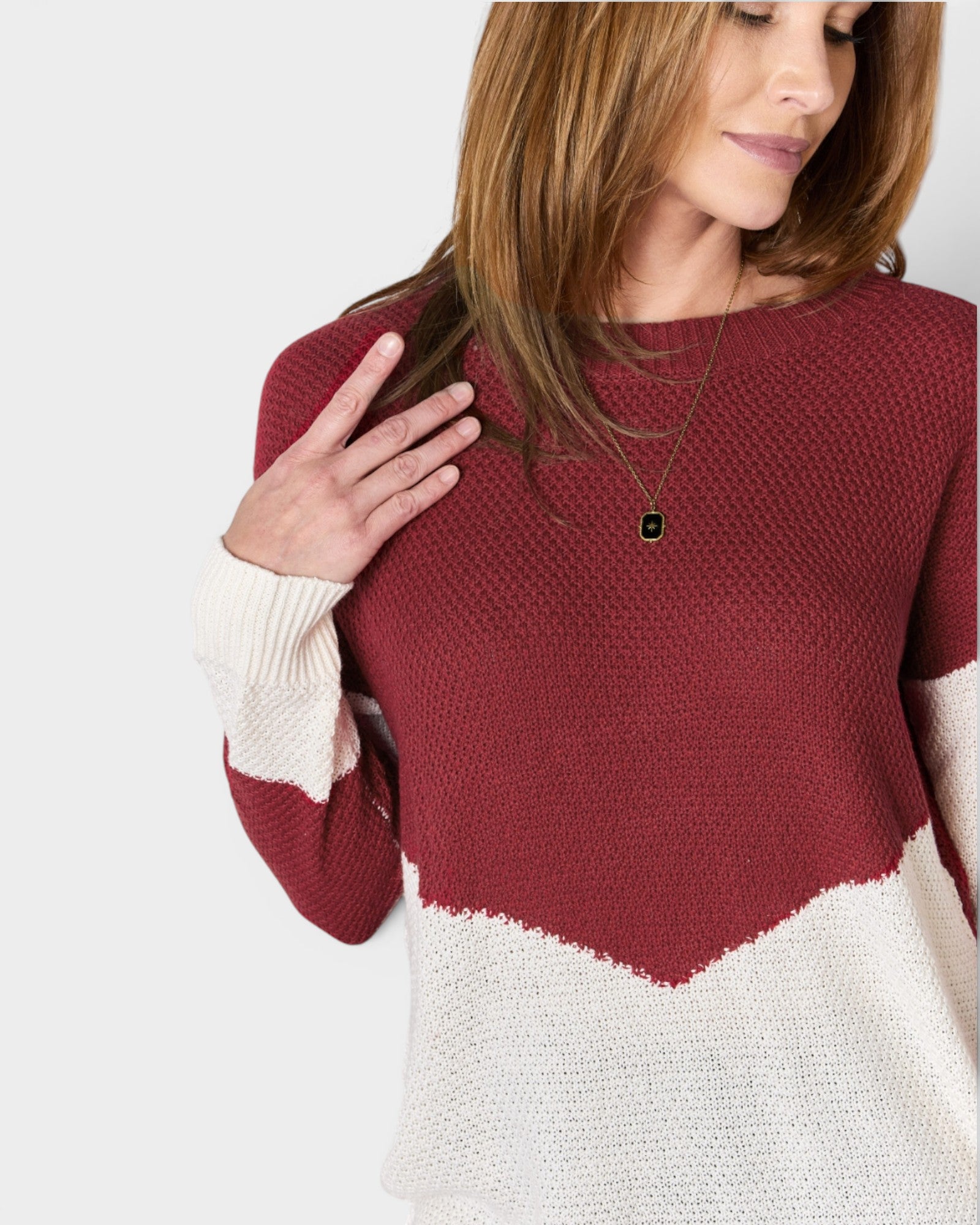 Woman wearing a red and white sweater with a plain background