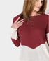 Woman wearing a red and white sweater with a plain background