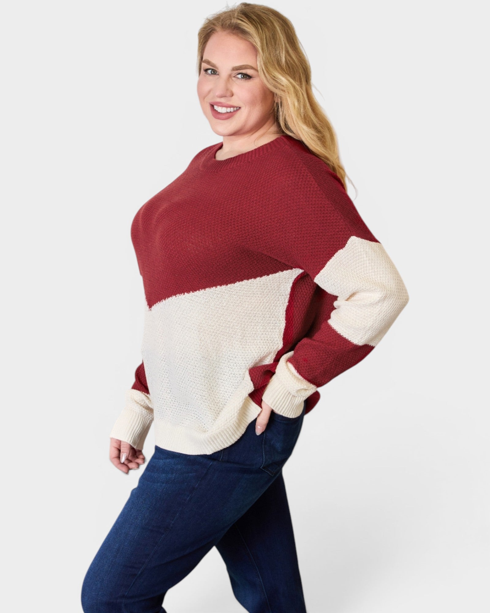 Woman wearing a red and white sweater with blue pants on a white background