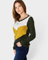 Woman wearing a color-blocked sweater with green, yellow, and white on a plain background
