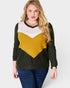 Woman wearing a sweater with a green, white, and yellow color block design on a plain background