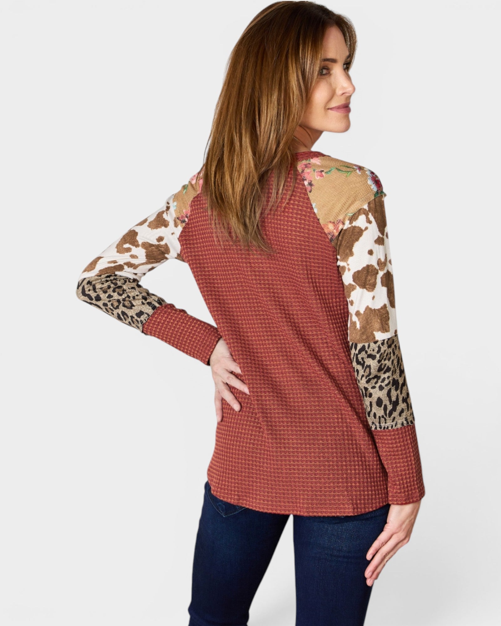 Woman wearing a red checkered shirt with animal print sleeves on a white background