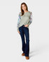Woman wearing a floral long-sleeve top and blue jeans on a white background