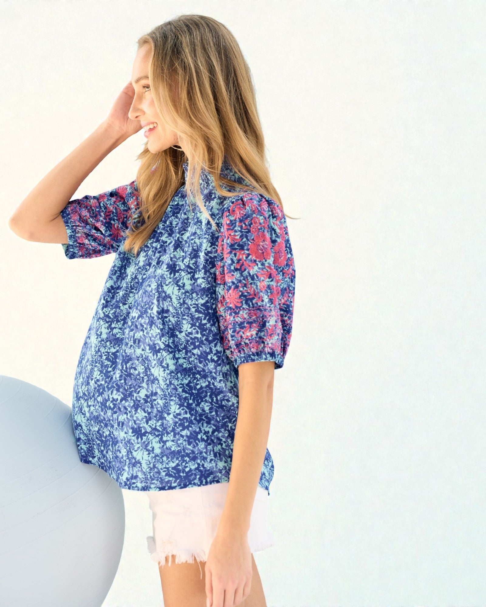Woman wearing a blue floral blouse against a white background
