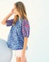 Woman wearing a blue floral blouse against a white background