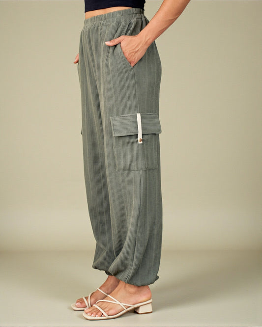 Person wearing green cargo pants on a beige background