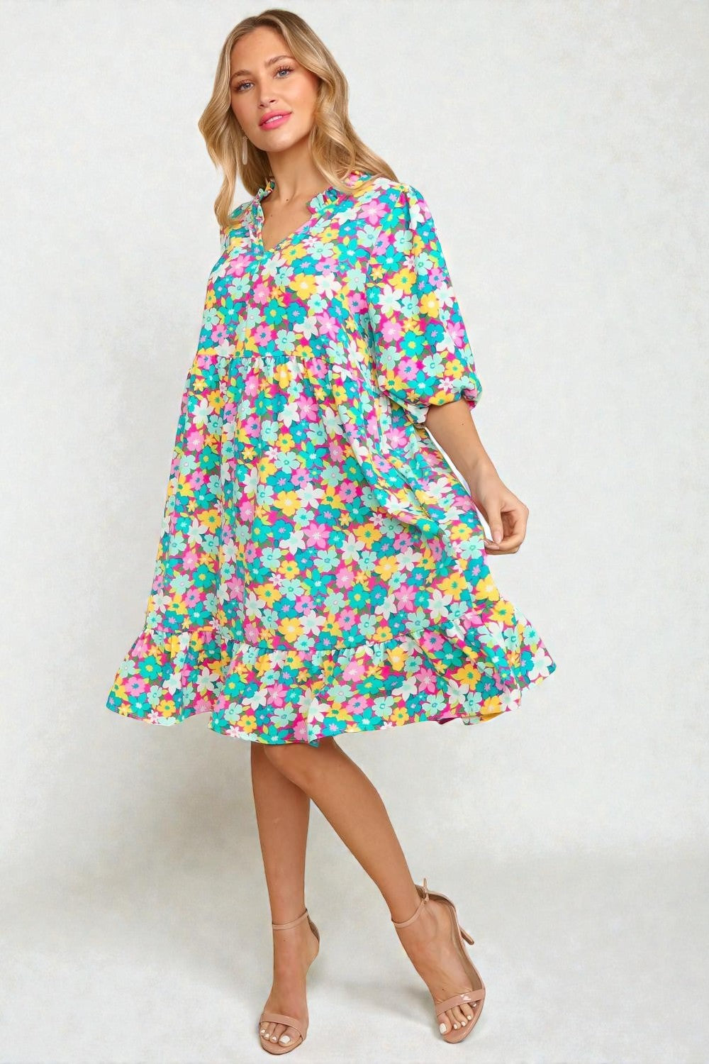 Woman wearing a colorful floral dress on a white background
