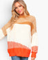 A woman wearing a chunky knit mock-neck sweater with horizontal color-blocked stripes in cream, mustard yellow, and bright orange, paired with blue jeans against a light gray studio background.