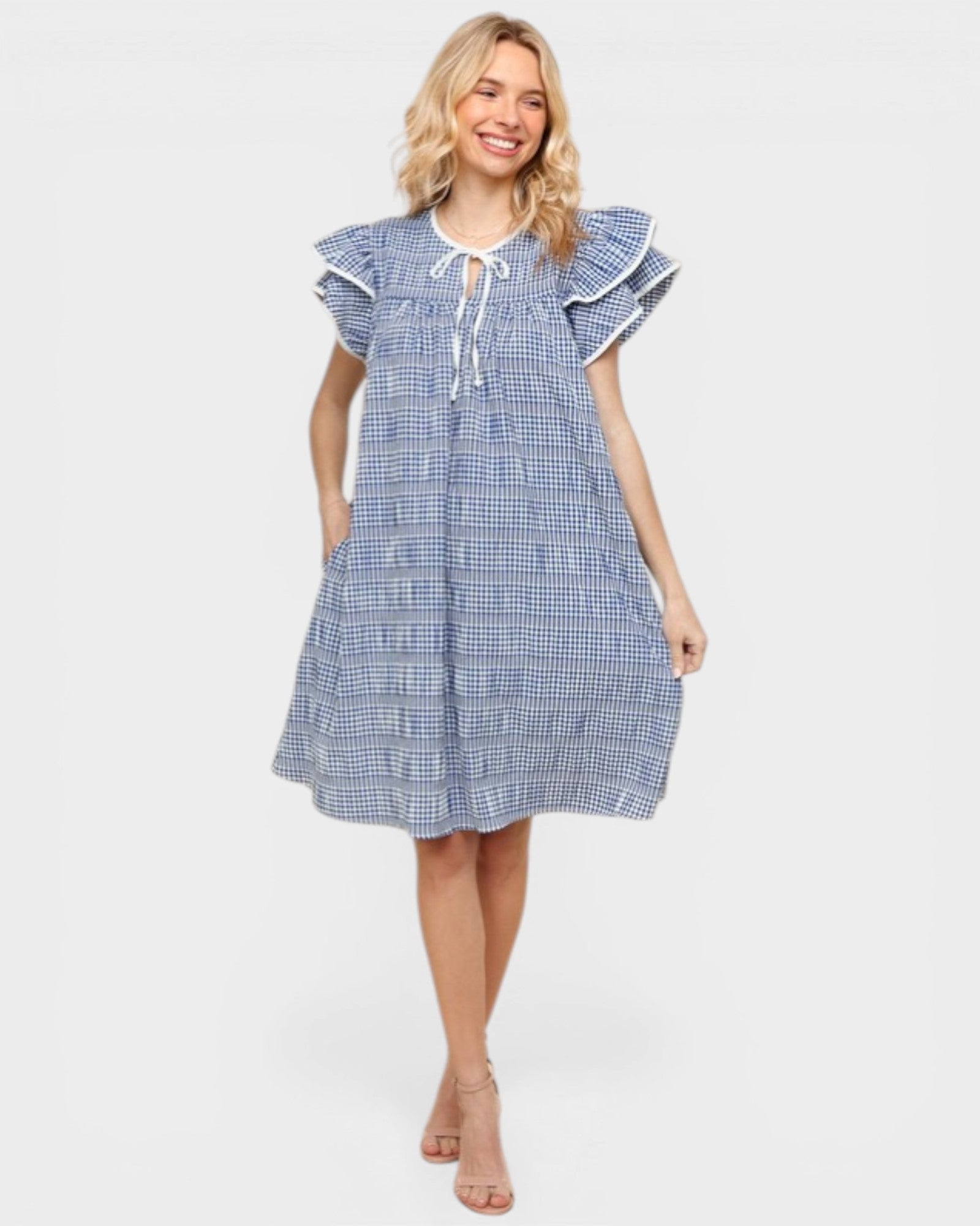 Woman wearing a blue checkered dress on a white background