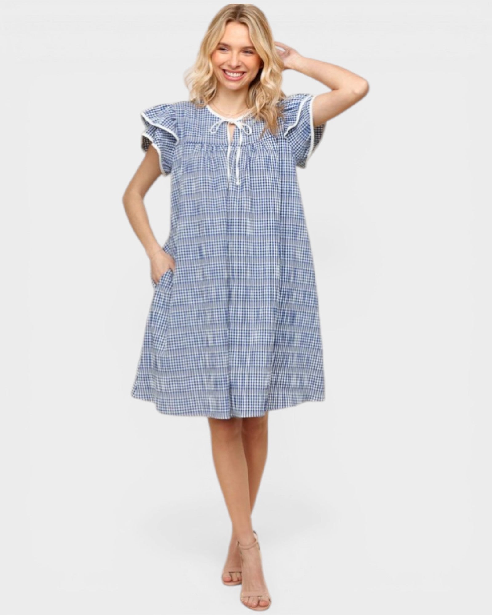 Woman wearing a blue checkered dress on a white background