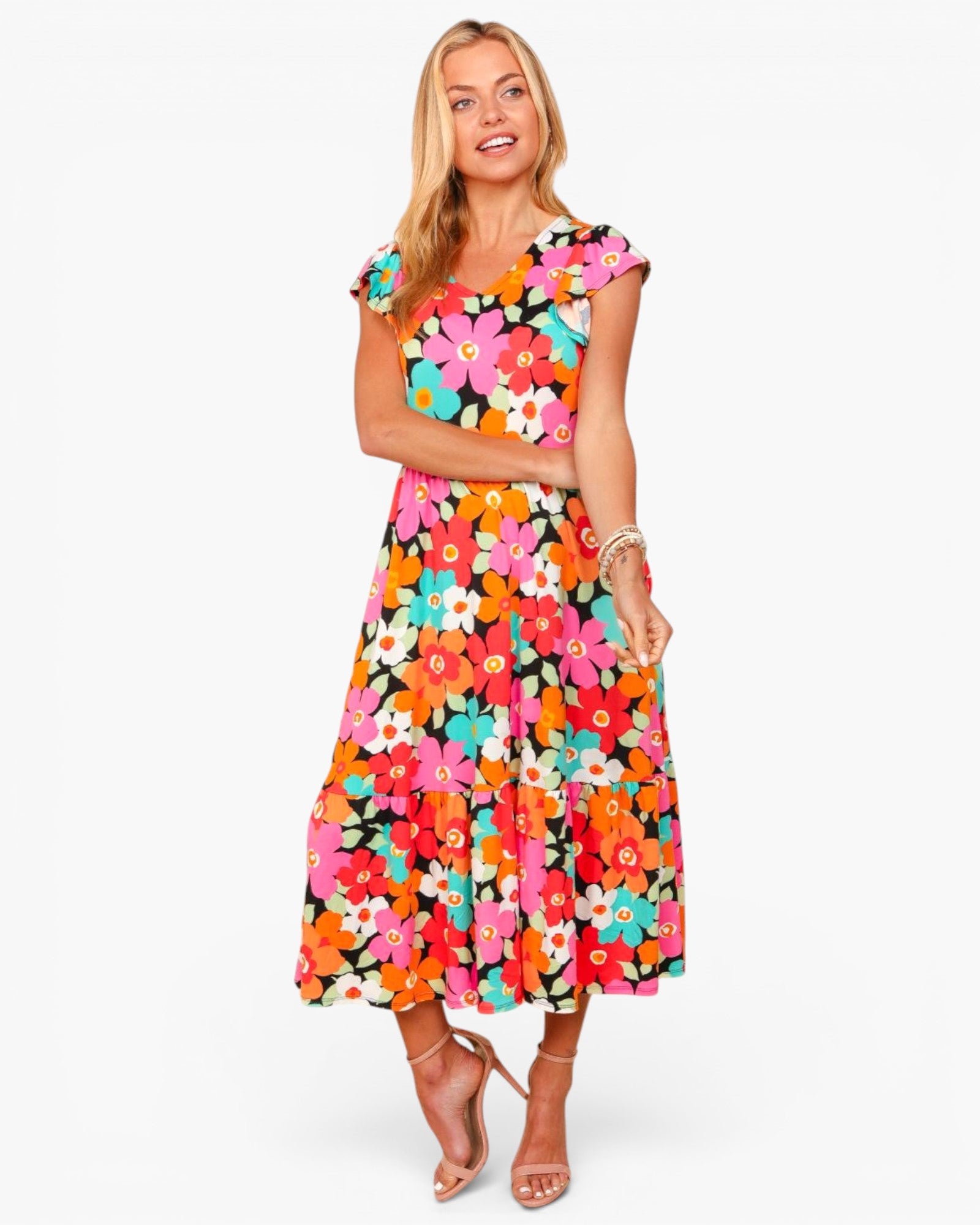 A woman modeling a vibrant, multicolor floral midi dress with ruffled cap sleeves, a scoop neckline, and a flared skirt, set against a plain light gray background.