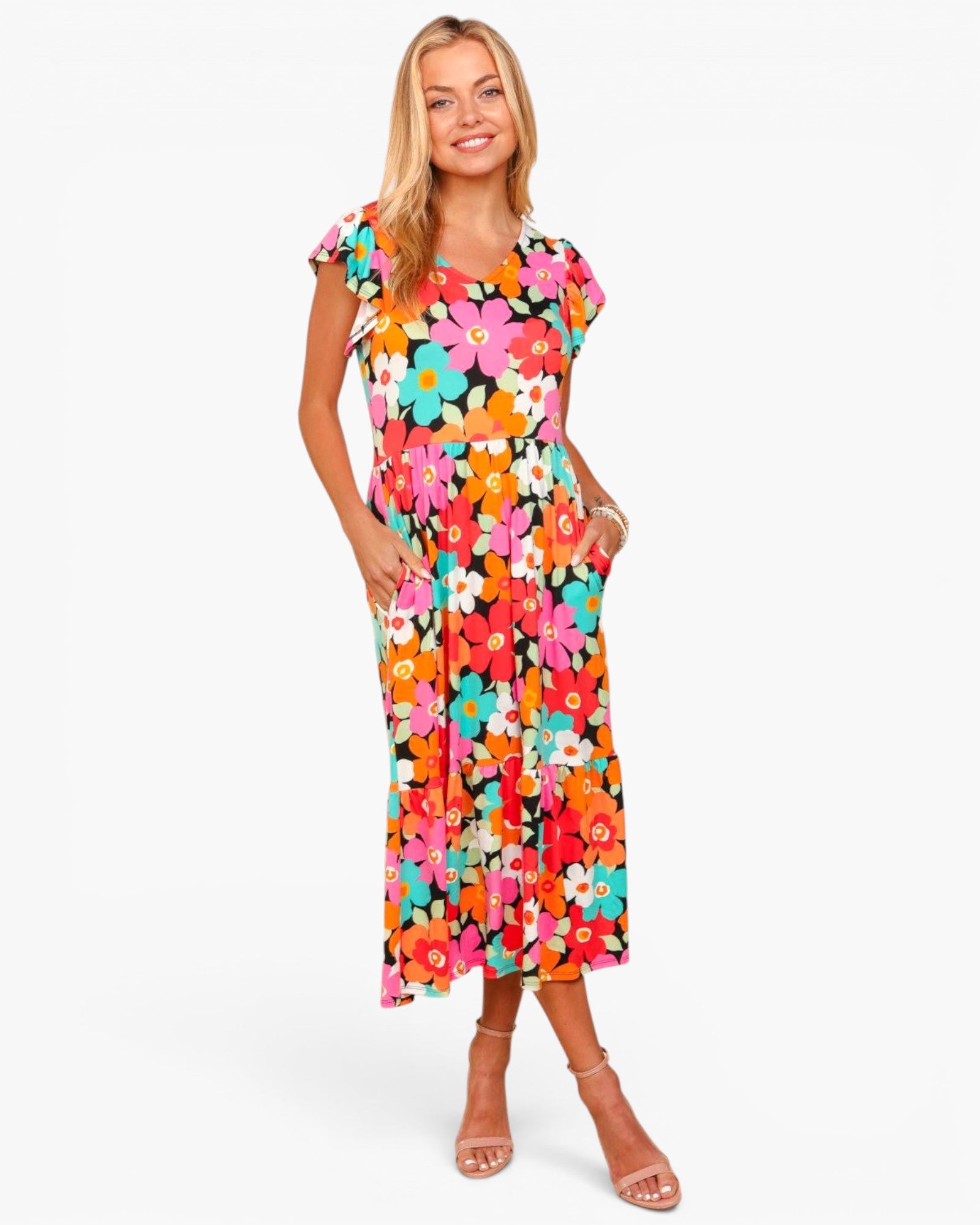 A woman modeling a short-sleeve midi dress with a vibrant multicolor retro floral print on a solid white background.