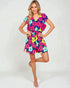 Woman wearing a colorful floral romper on a white background