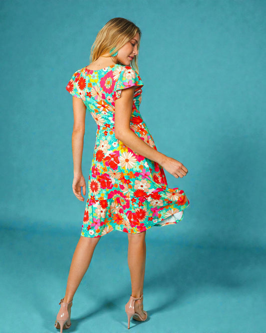 Woman wearing a colorful floral dress against a blue background