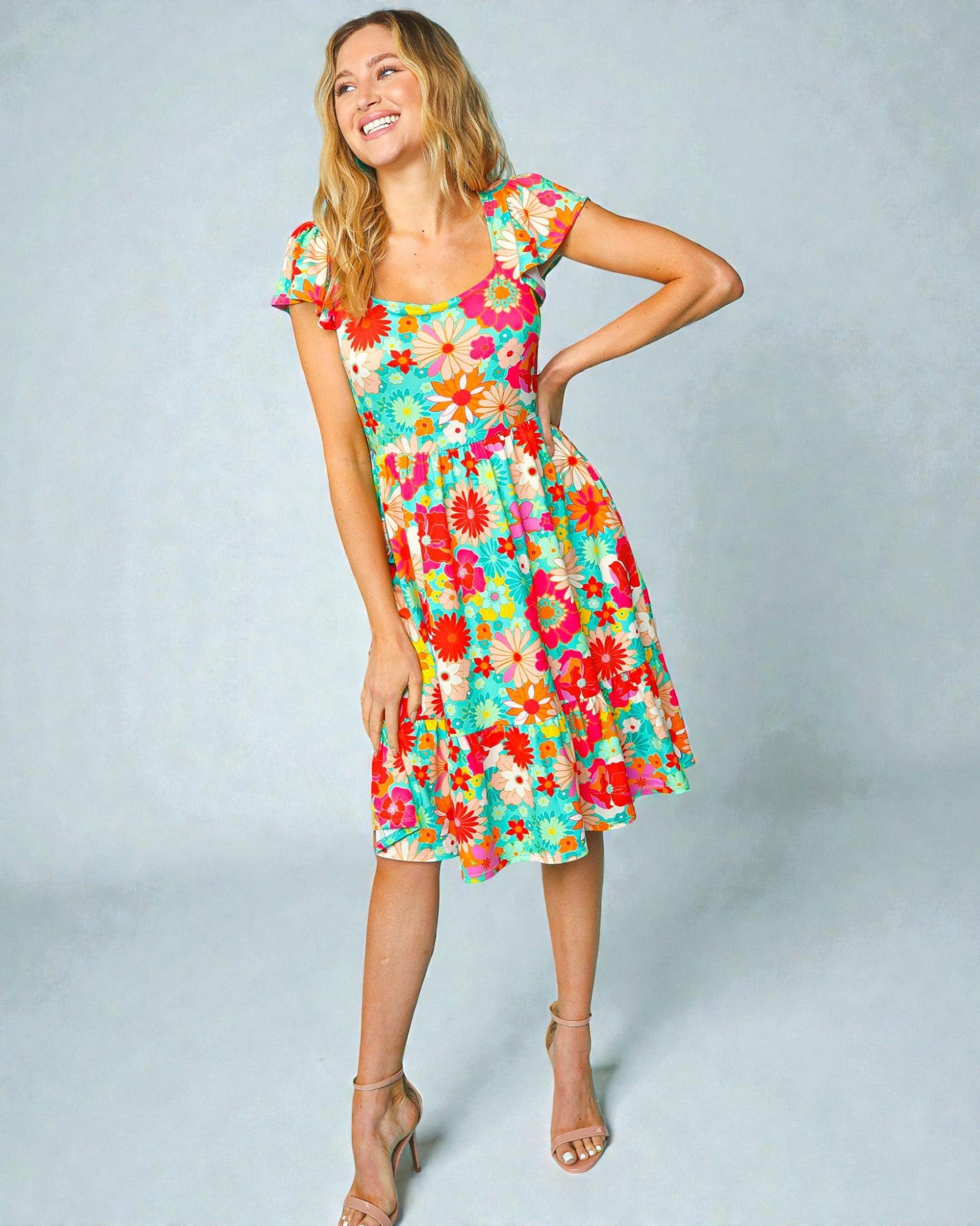 Woman wearing a colorful floral dress against a light gray background